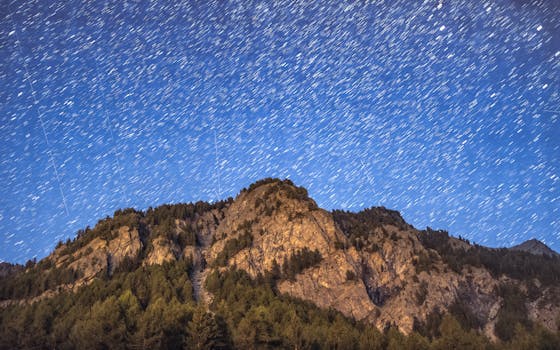 Capture of a mountain under a star-filled sky showcasing stunning night photography.