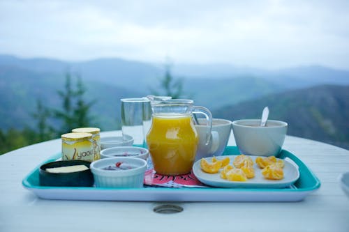 Juice and Food Served on Tray on a Terrace 