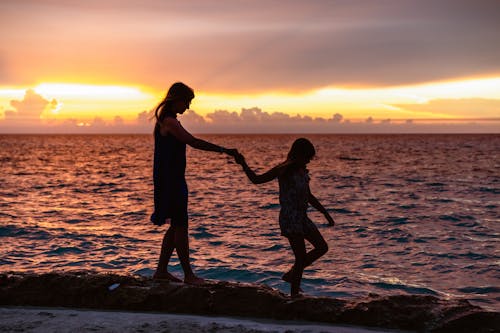 Mother and Daughter Walking on Seashore