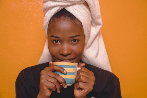 Woman with a Towel on Her Head Drinking from a Cup