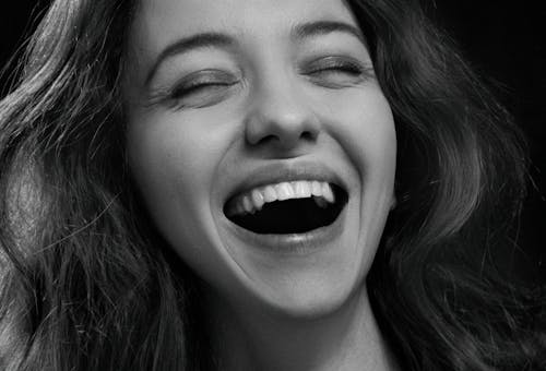 Grayscale Photo of Woman Laughing