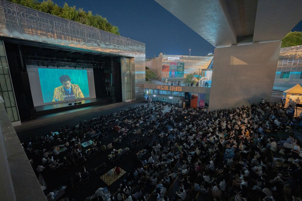 Film festival audience watching a screening outdoors at night