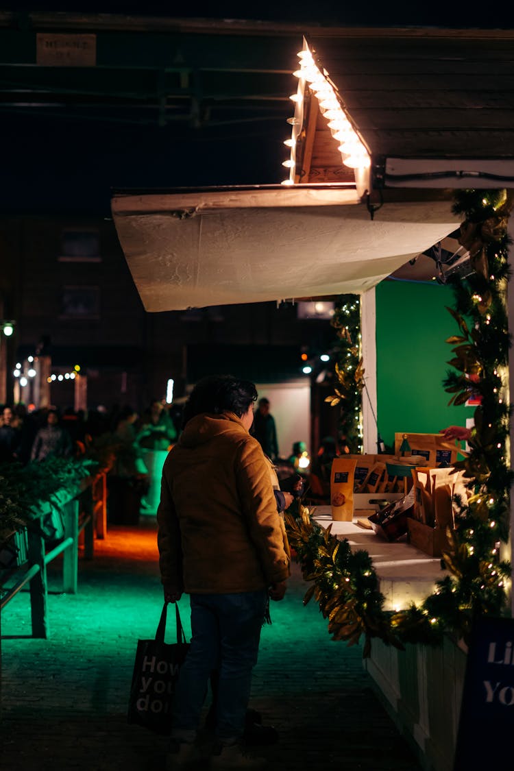 People Near Illuminated Stalls At Christmas Market