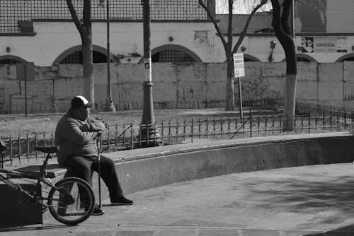Man with a Bike Sitting in Park in Black and White 