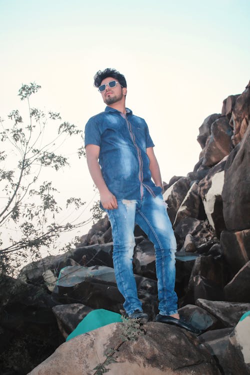 Man Standing On Big Rock Of Mountains