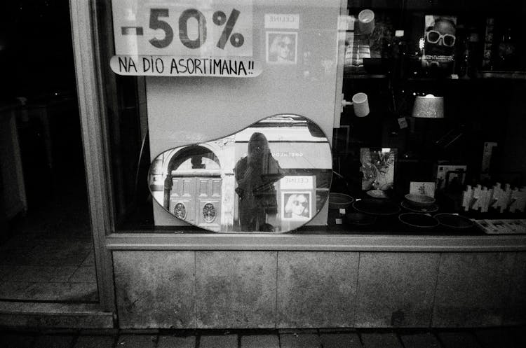 Woman Taking Picture In Mirror In Shop Window