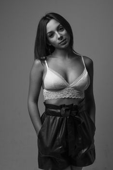 Chic black and white studio portrait of a woman posing in fashion attire.
