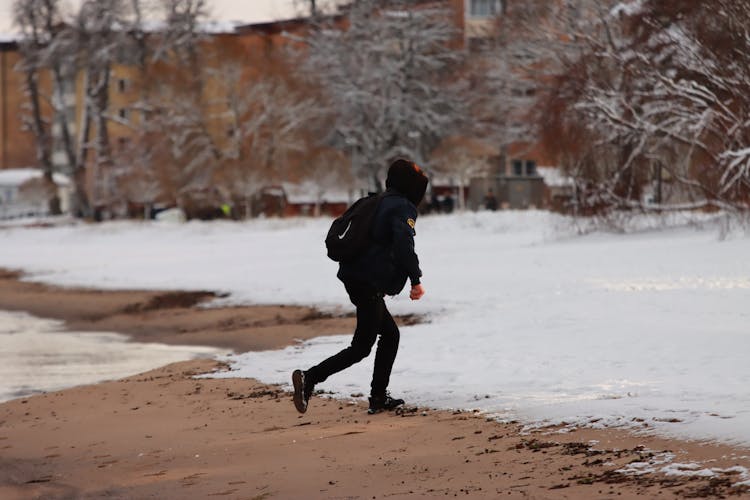 A Person Running On A Snow Covered Ground