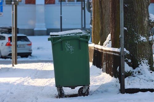 Green Dustbin on a Snowy Street