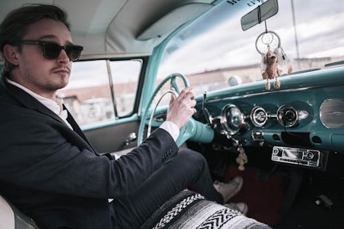 Elegant Man Driving a Vintage Car
