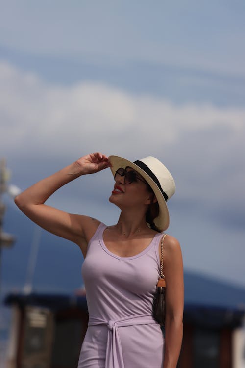 Photo of a Woman in a Light Pink Dress and Sun Hat