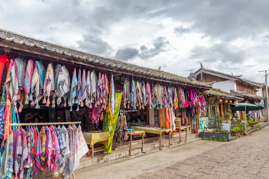 Explore a vibrant outdoor market with a variety of colorful scarves displayed under traditional rooftops.