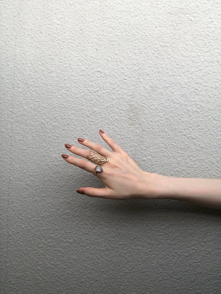 A Person With Brown Manicured Nails Wearing Rings