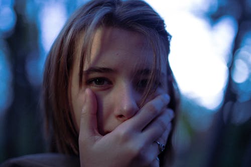 A Close-up Shot of a Woman Covering Her Mouth