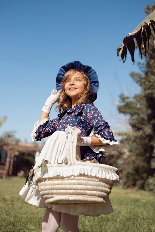 Photo of a Young Girl carrying a Basket