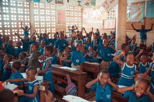 A group of schoolchildren energetically participating in a classroom activity indoors. 14554003