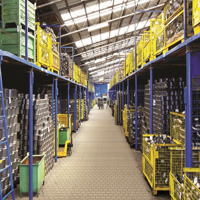 A stockroom aisle of racking stacked with crates — photo by endura tiles on Pexels