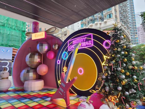 Vibrant Christmas setup in Hong Kong featuring neon signs and a decorated tree for a festive celebration.