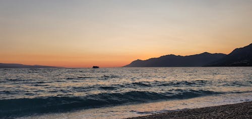 Безкоштовне стокове фото на тему «берег моря, гори, Захід сонця»