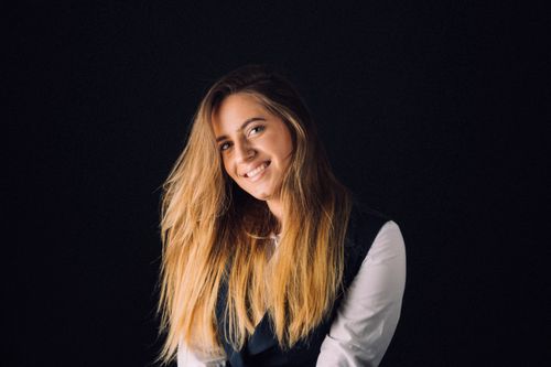 Free Elegant portrait of a smiling woman with long, flowing hair against a dark background. Stock Photo