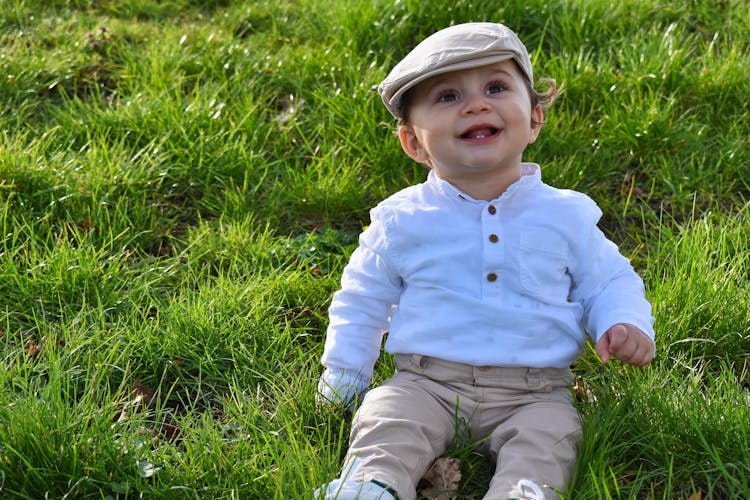 Baby Boy Sitting On Grass