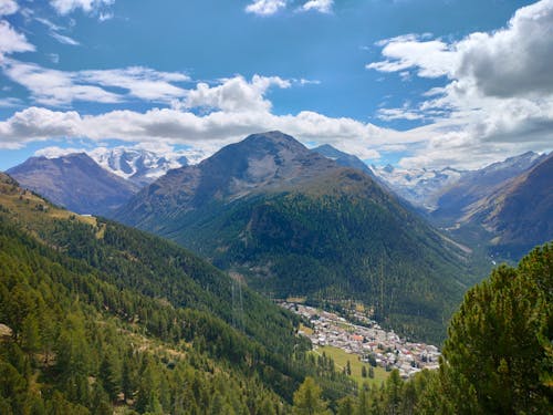 An Aerial Photography of Green Trees on Mountain Under the Blue Sky and White Clouds