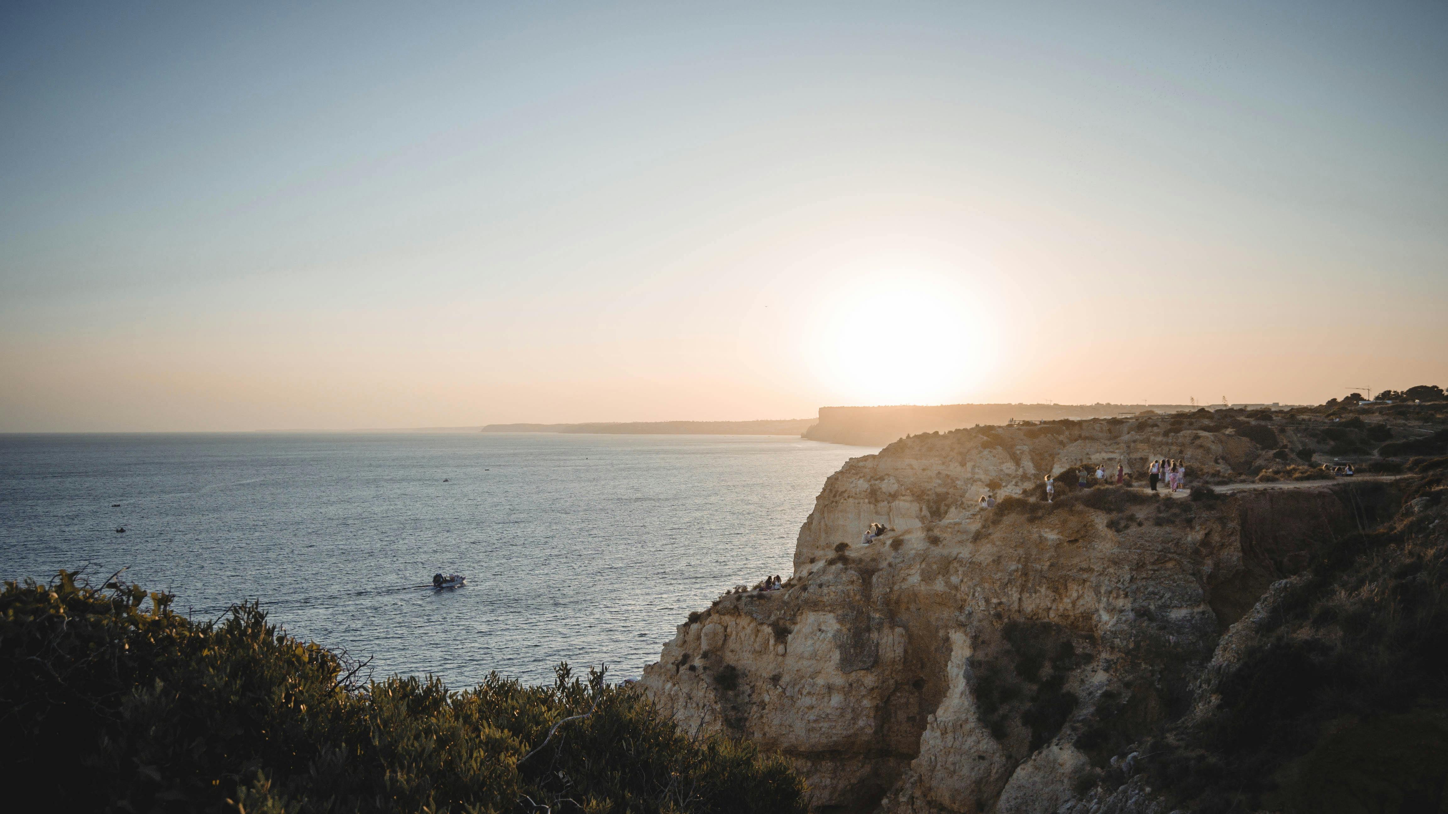 Scenic coastal landscape in Lagos, Portugal, capturing a stunning sunset over the cliffs.