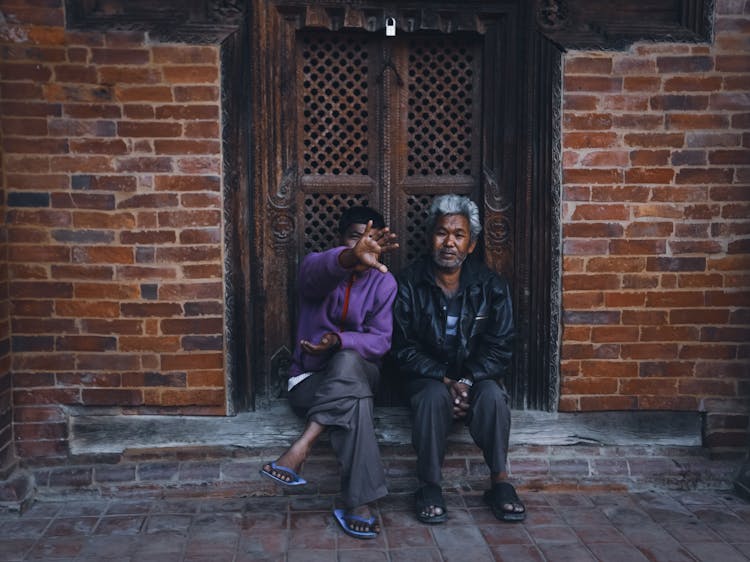 Two Men Talking On The Doorstep