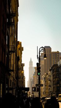 A lively New York City street scene at sunset featuring historic buildings and traffic.