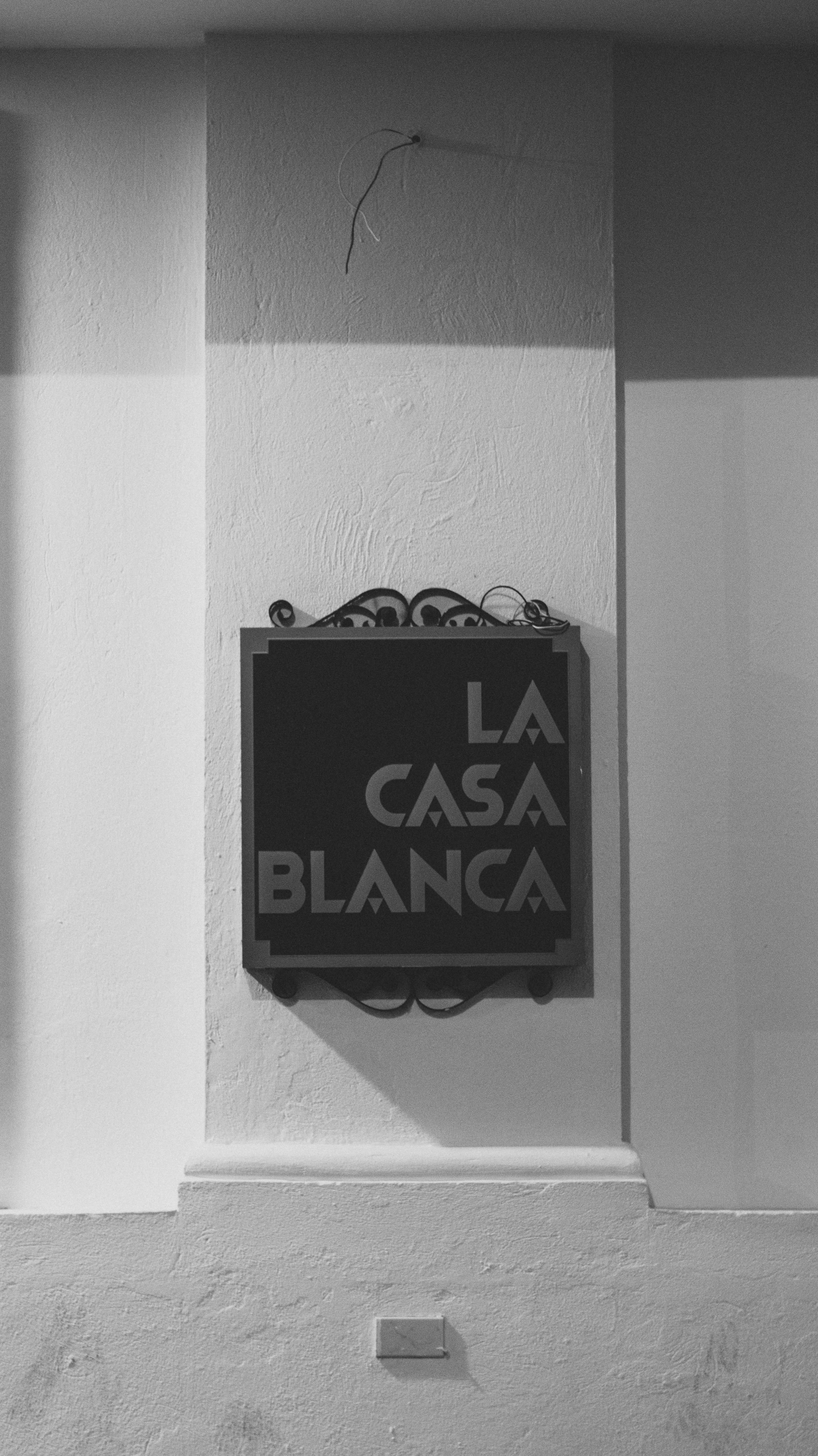 monochrome shot of a la casa blanca signage on a wall