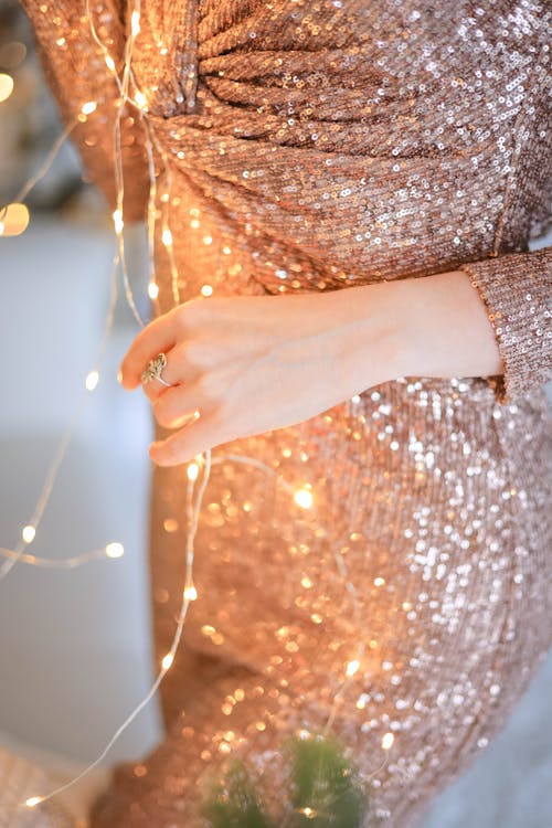 Person in Sequin Dress Holding a Fairy Lights 