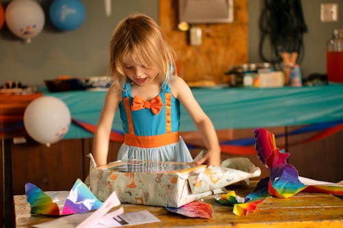 Free A Girl Unwrapping a Gift Stock Photo