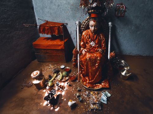 Free A young girl dressed as a goddess in a vibrant Hindu ceremony setting. Stock Photo