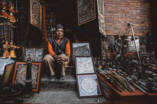 Free A man selling traditional art and crafts in a bustling bazaar. Stock Photo
