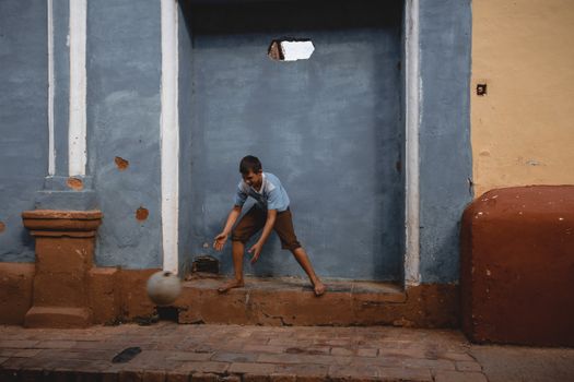 A Boy Playing a Ball in a Building Niche