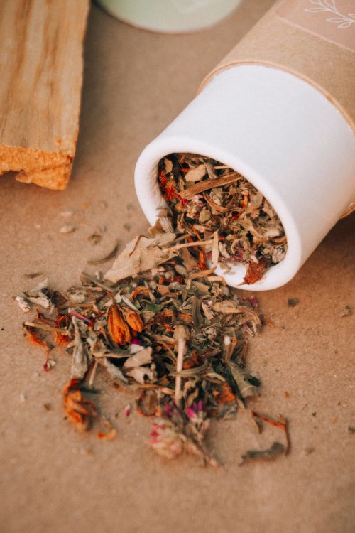 Free A close-up of dried herbs spilling from a cardboard tube in a natural setting. Stock Photo