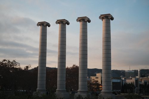 Free Low-angle view of the iconic four columns at Montjuïc in Barcelona against a serene sky. Stock Photo