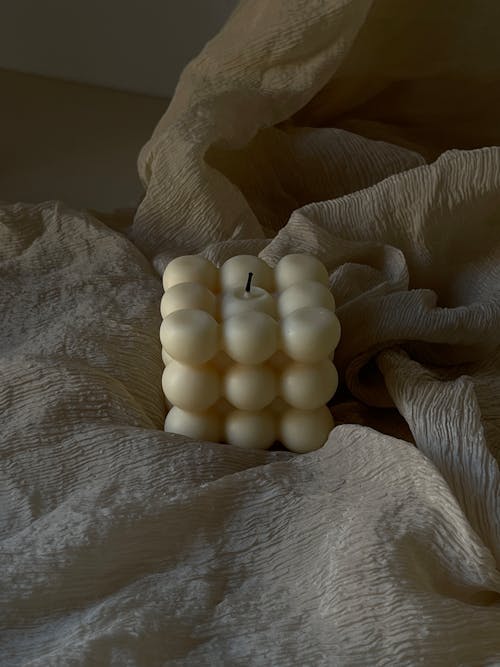 Candle Placed on a Draped Beige Cloth