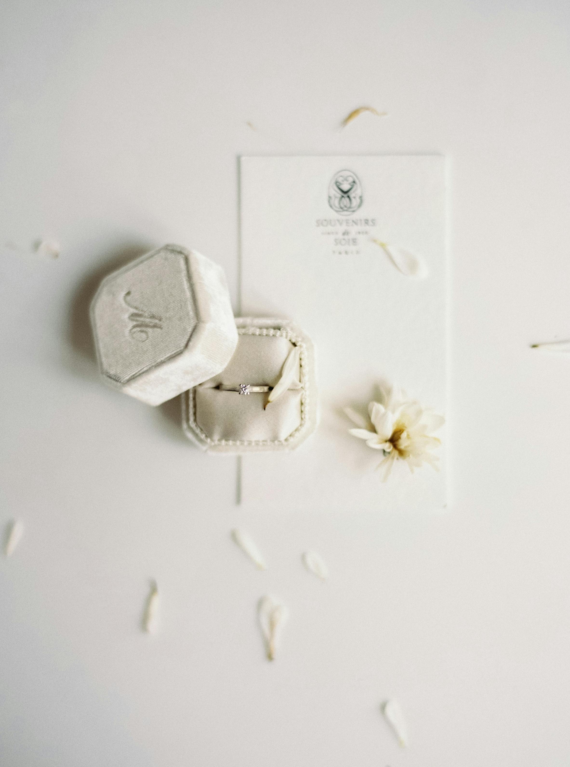 Top view of a luxury engagement ring in a velvet box with floral accents, symbolizing elegance and love.
