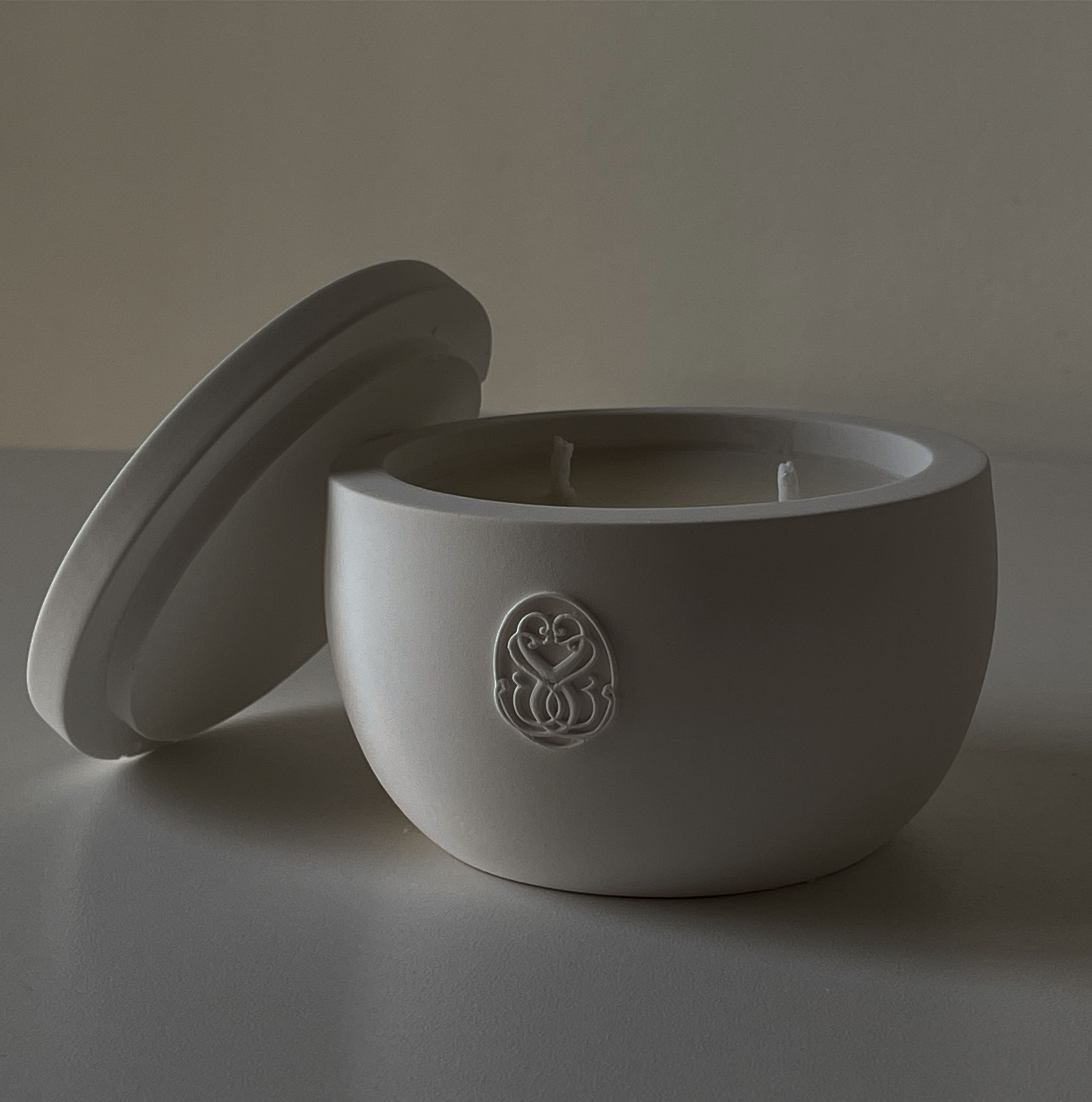 Minimalist white ceramic candle holder with lid, perfect for home decor.