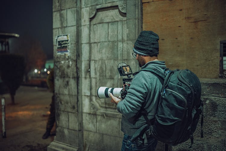 Man With A Backpack  Taking Photo