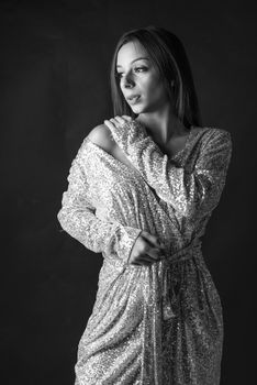 Black and white portrait of a woman posing in a glamorous gown, showcasing elegance.