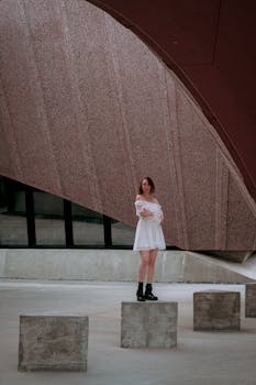 Woman standing in modern architectural environment, capturing an urban vibe.