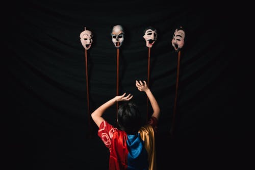 Woman in Robe with Theater Masks on Black Background