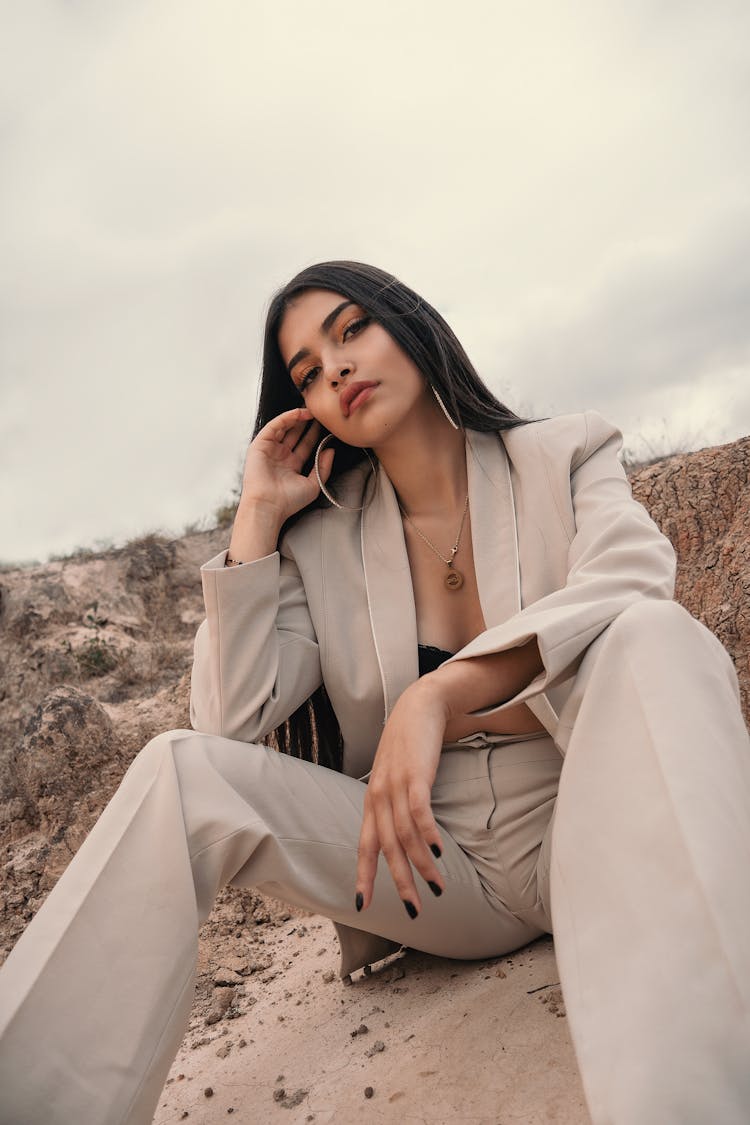 Elegant Woman In A Beige Suit Posing On Sand