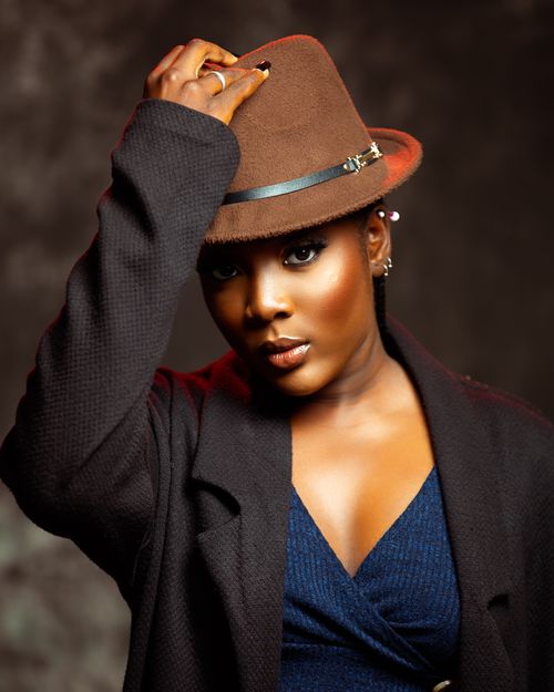 Free Elegant studio portrait of a woman posing in a brown hat and dark coat. Stock Photo