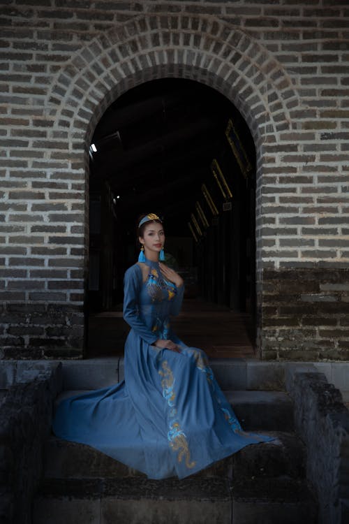 Woman in Blue long Dress Sitting on the Stairs