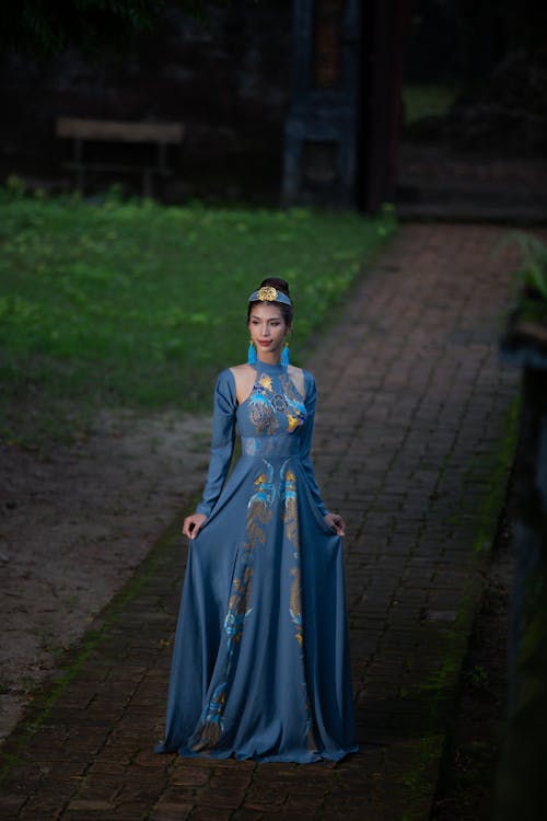 Woman in Blue Dress Standing on a Pathway