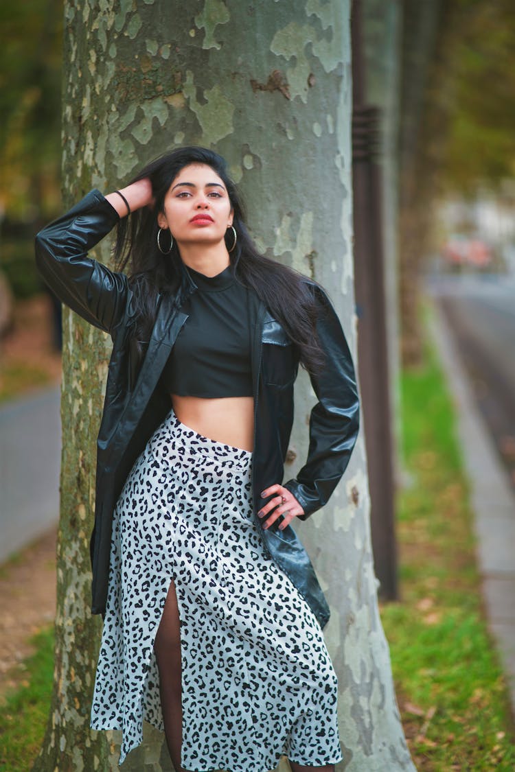 Woman In Jacket And Skirt Posing By Tree