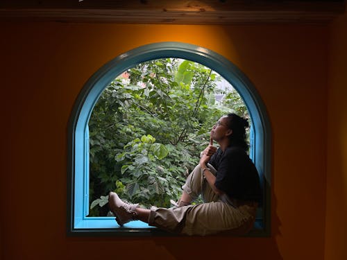 Woman Relaxing at Arched Window
